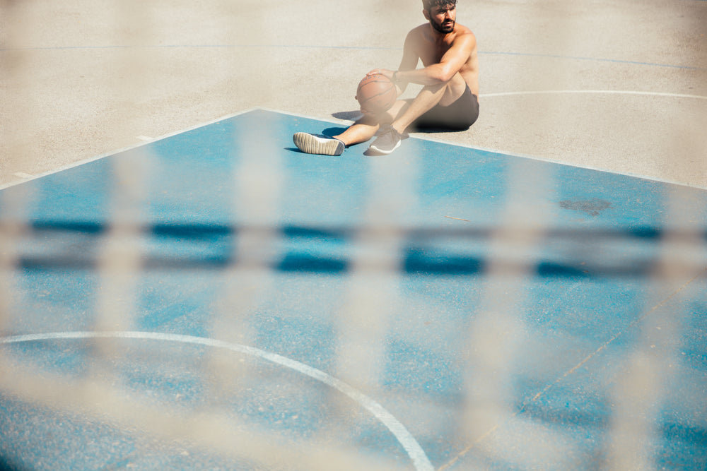 man sitting on basketball court