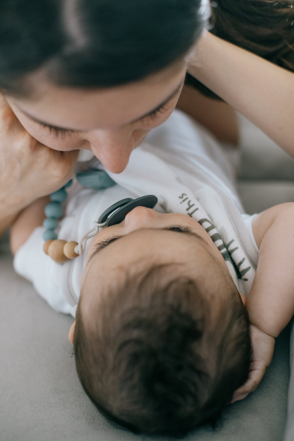 a baby and a womans face held close together