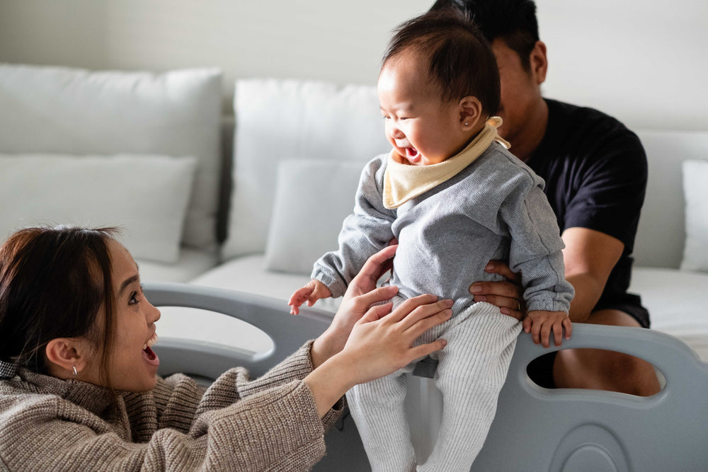 a baby smiling and looking at their mother