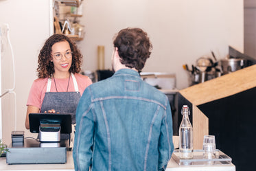 a barista chats to a customer at the cash till