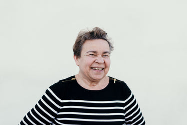 a beaming mature woman in a striped sweater