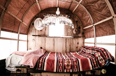 a bed with a blanket inside a caravan