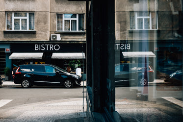 a black car parked outside a bistro