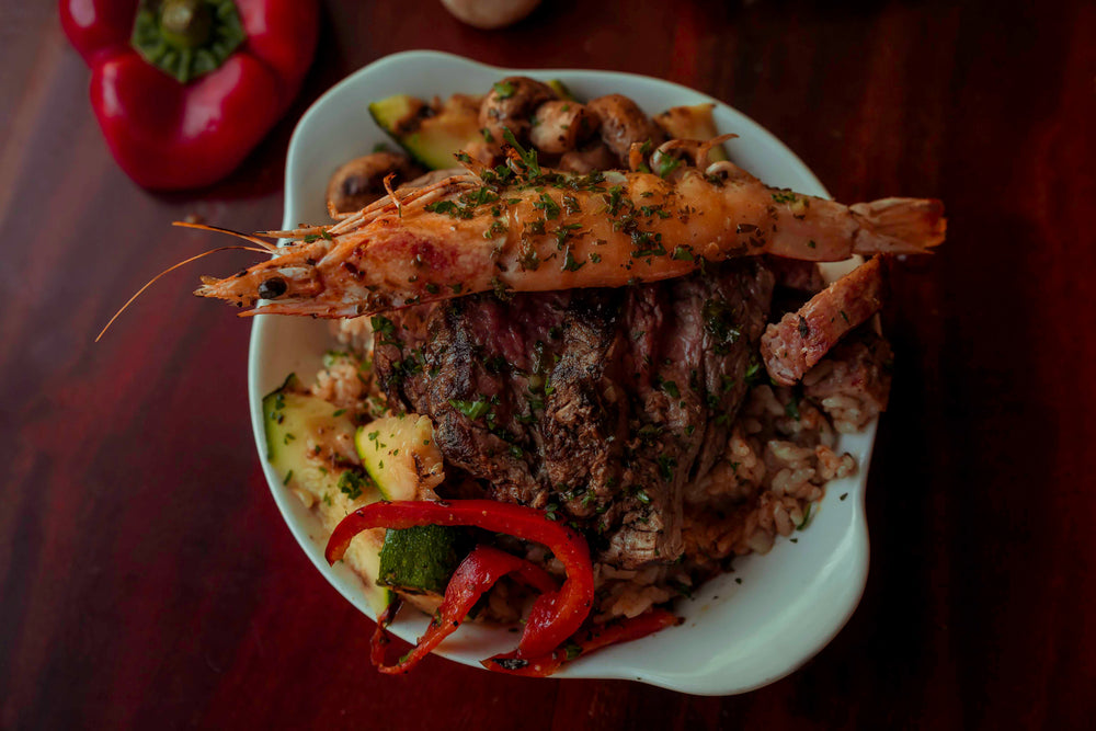 a bowl of cook vegetables with red meat and seafood