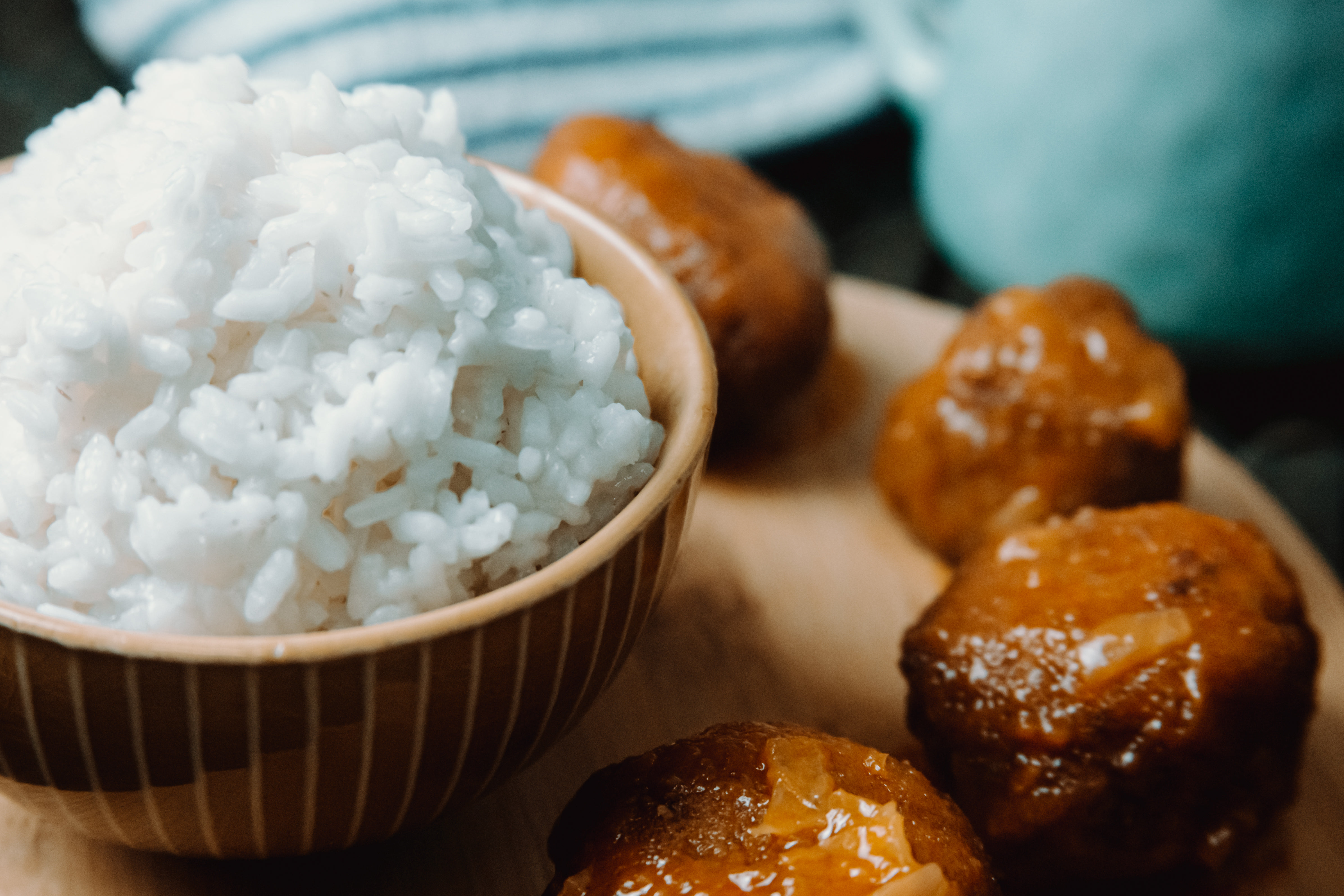 A Bowl Of White Rice Surrounded By Balls Of Dough