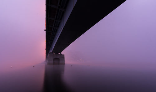 一座桥坐落在粉红色和紫色的浓雾中
