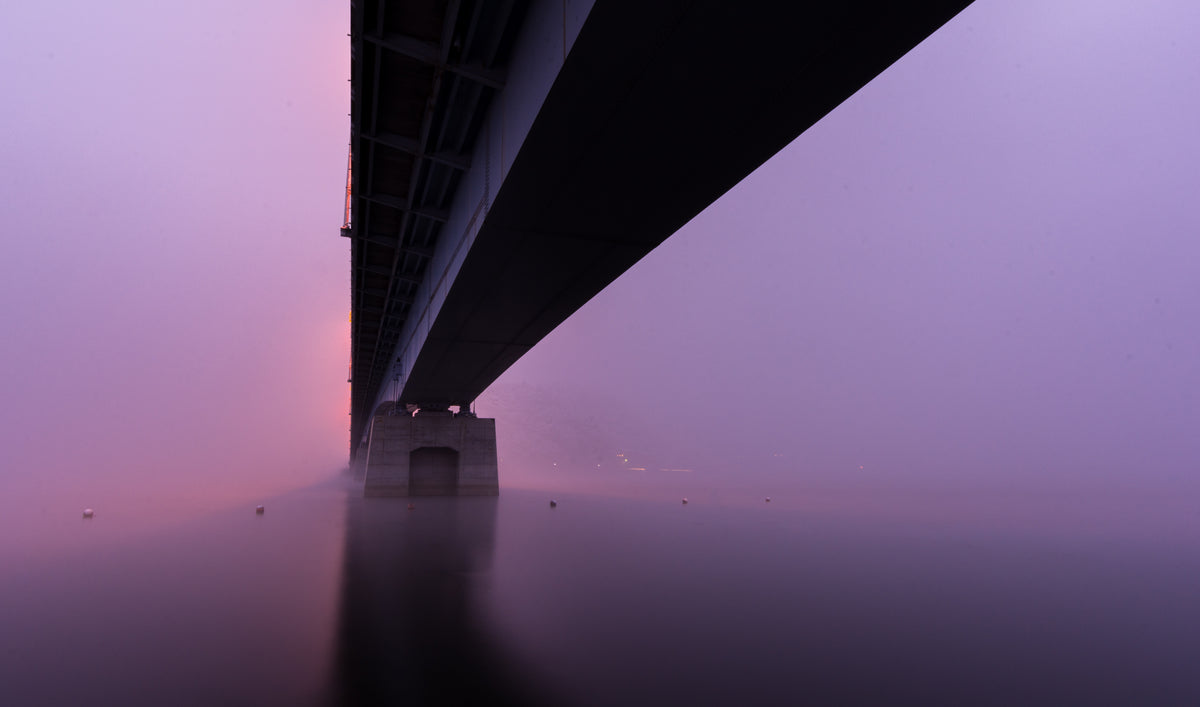 a bridge sitting in thick pink and purple fog