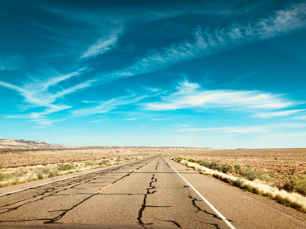 明亮的蓝天在崎岖的沙漠公路上