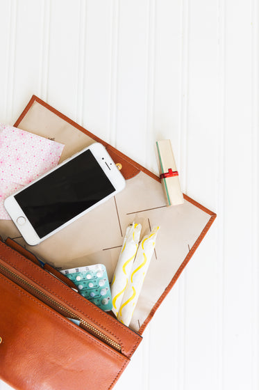 a brown leather purse spills feminine products