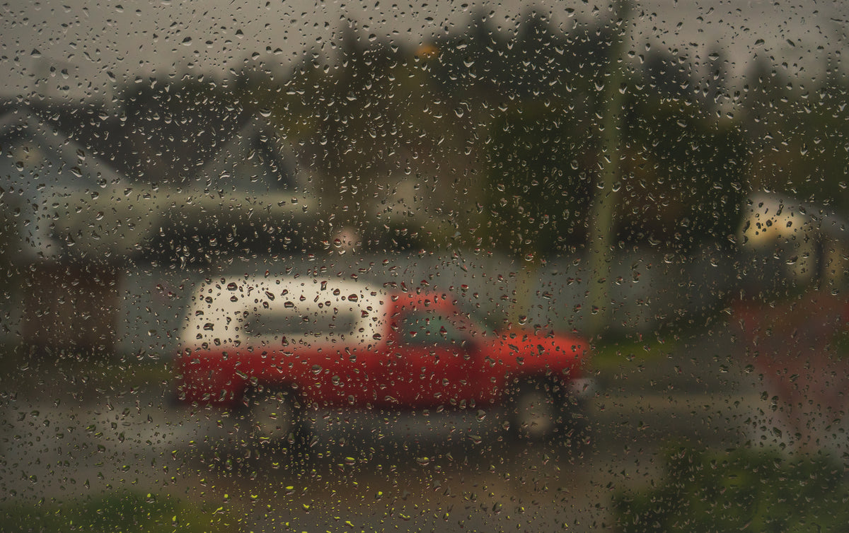 a car viewed through a rain-speckled window.