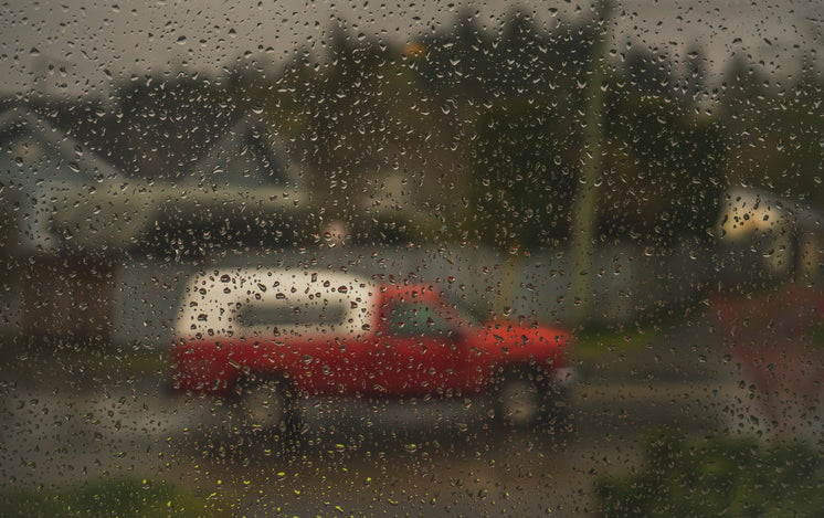 A Car Viewed Through A Rain-Speckled Window.