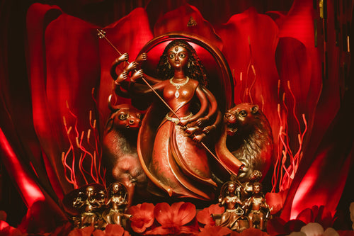 a carved figurine on a red background