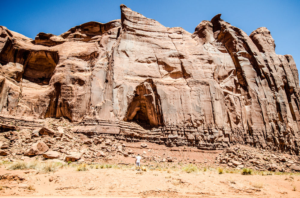 a cave in the side of a sandstone hill in the desert