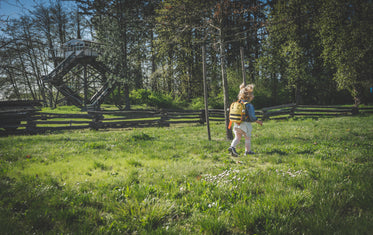 a child runs through the a grassy clearing