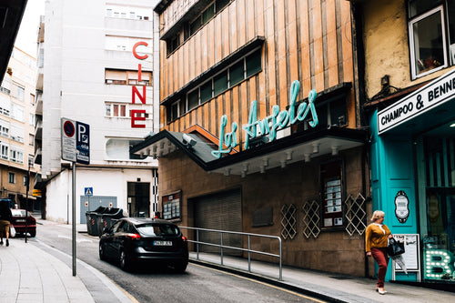 a cinema in a shabby-chic street with neon lights
