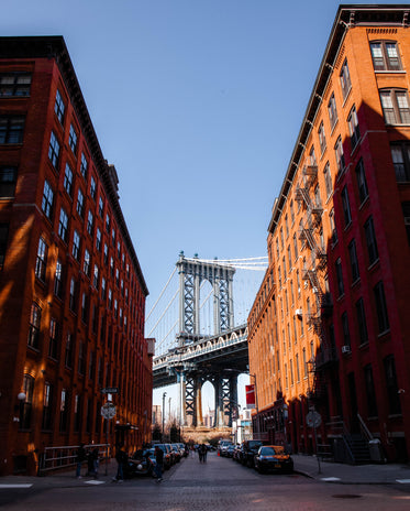 a city street down under the manhattan bridge overpass