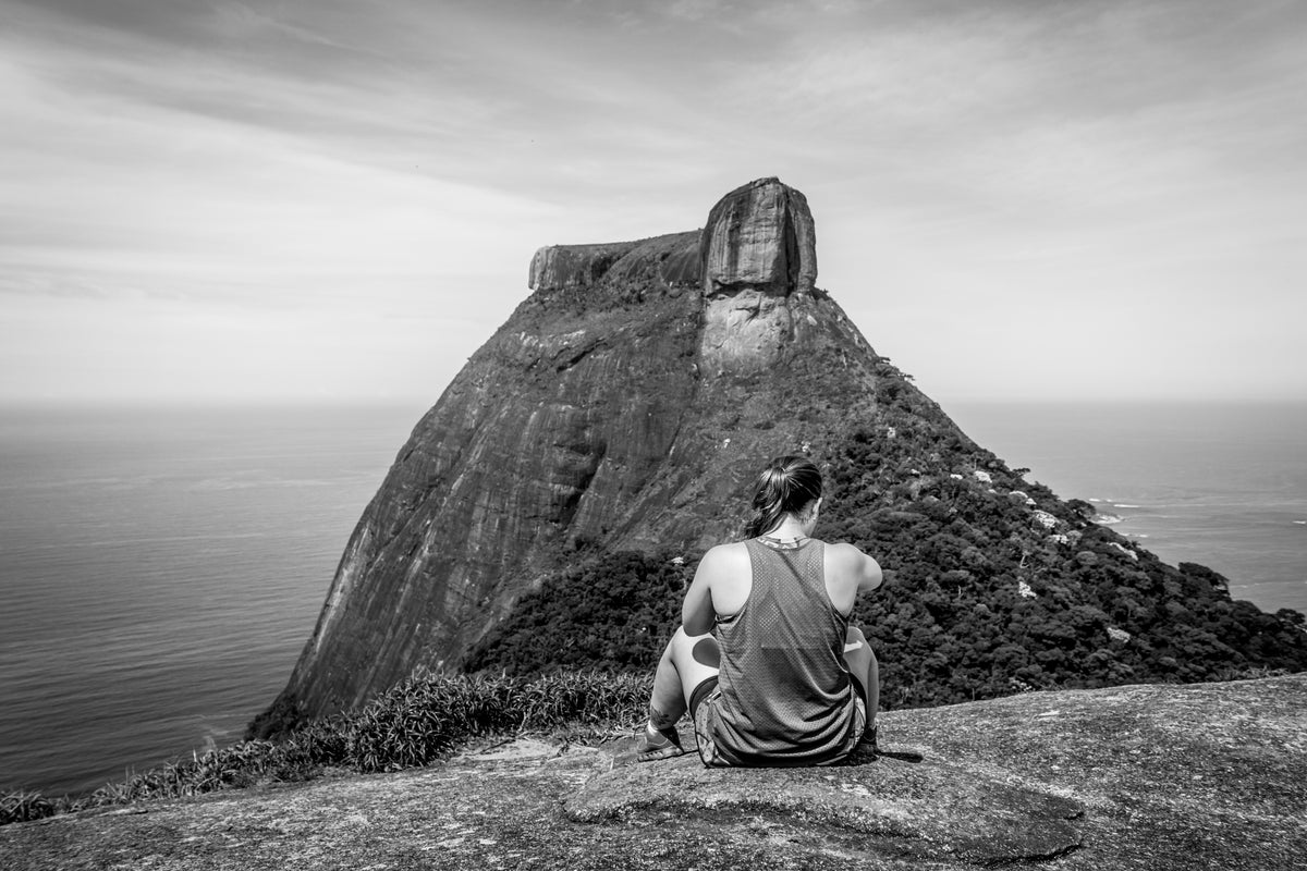 a climber sits atop a hill surveilling her next challenge