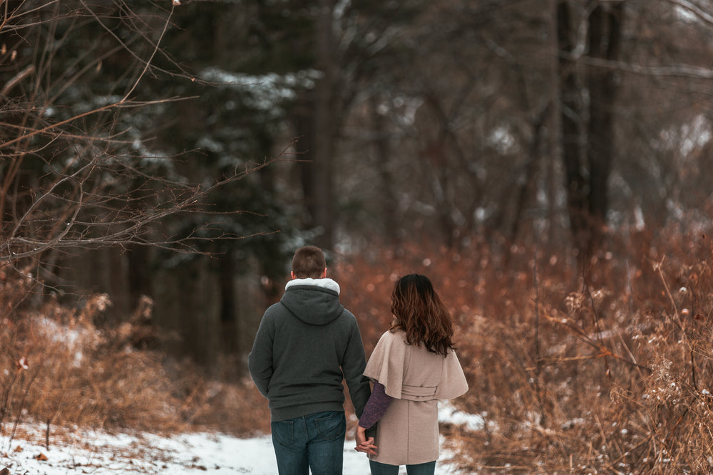 a close up of a couple strolling through winter