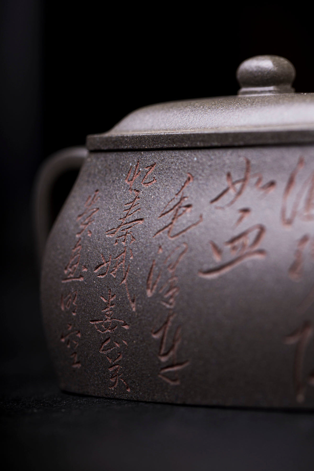 a close up view of letters carved on a grey teapot