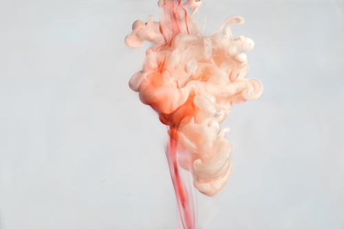 a cloud of pink paint in water