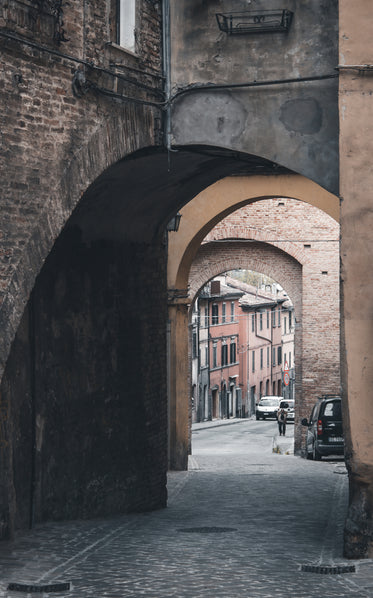 a cobblestone street through an archway