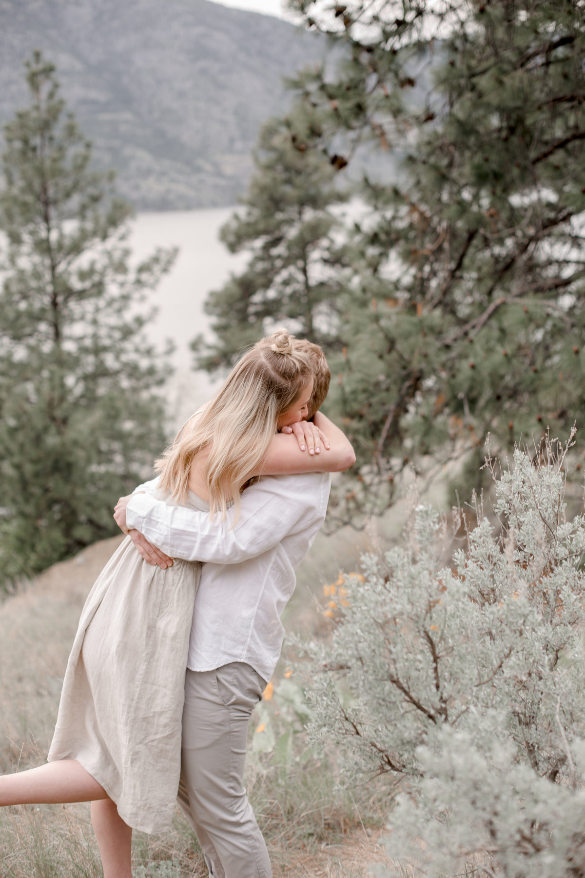 a couple embrace on a mountain side