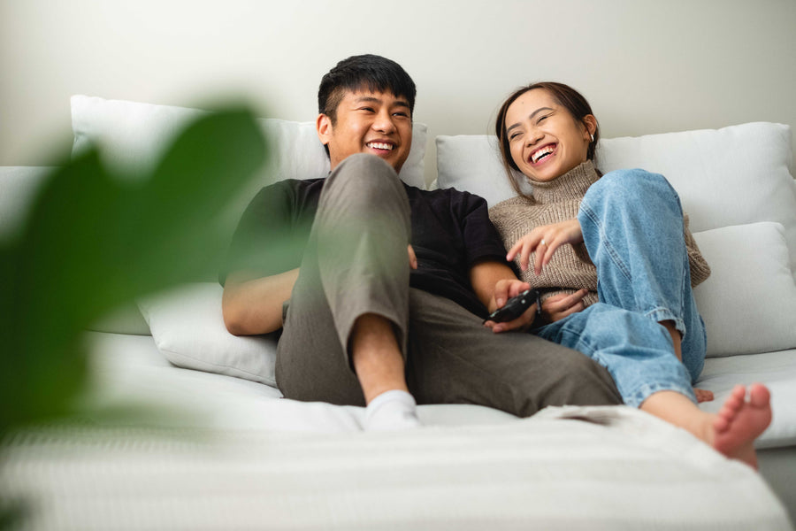 Happy couple laughing together on their couch