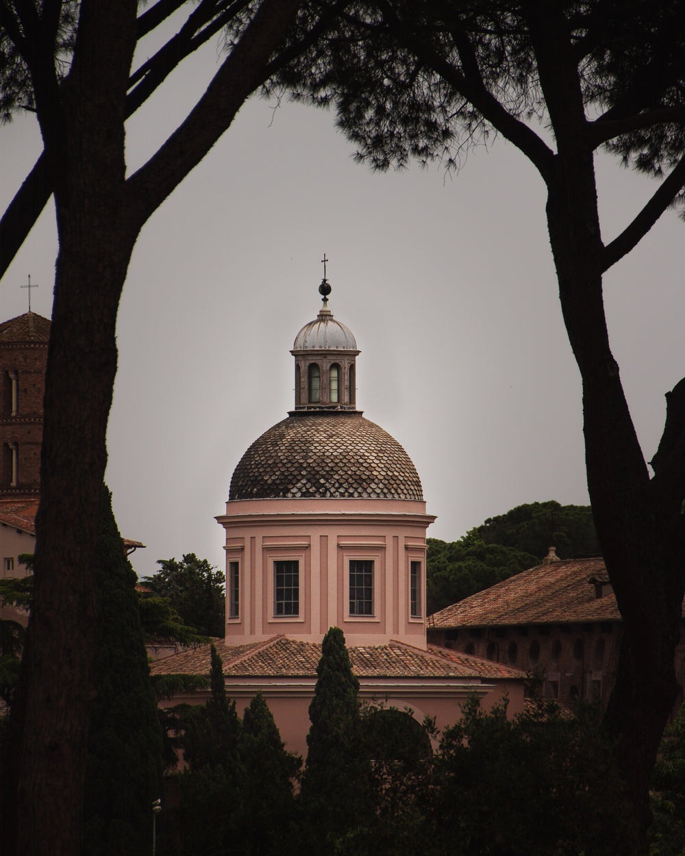 a crucifix on a spire against a grey sky