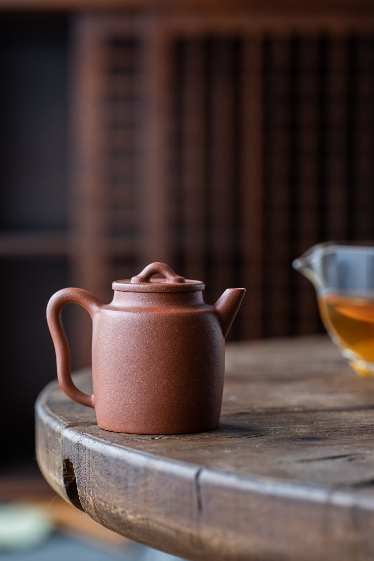 a dark ceramic teapot on a wooden table