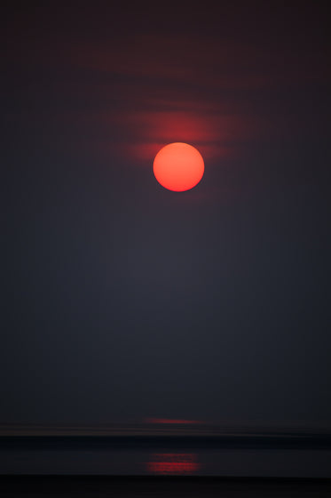 a dark night sky with a vibrant sun starting to set