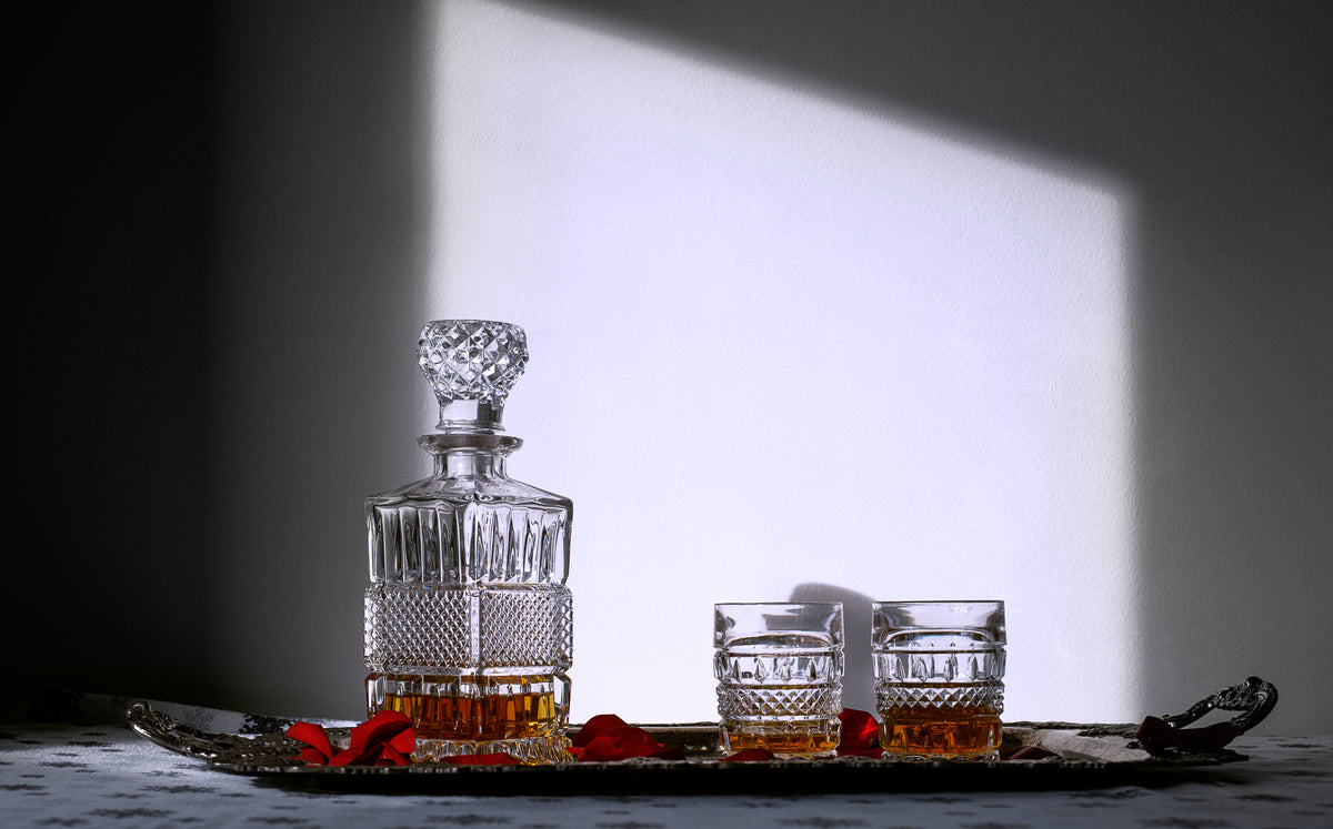 a decanter and matching cups on a silver tray