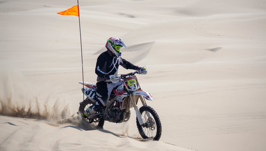 Browse Free HD Images of A Dirt Bike Racer Spins Sand Riding Over Dunes