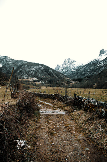 a dirt road below the mountains