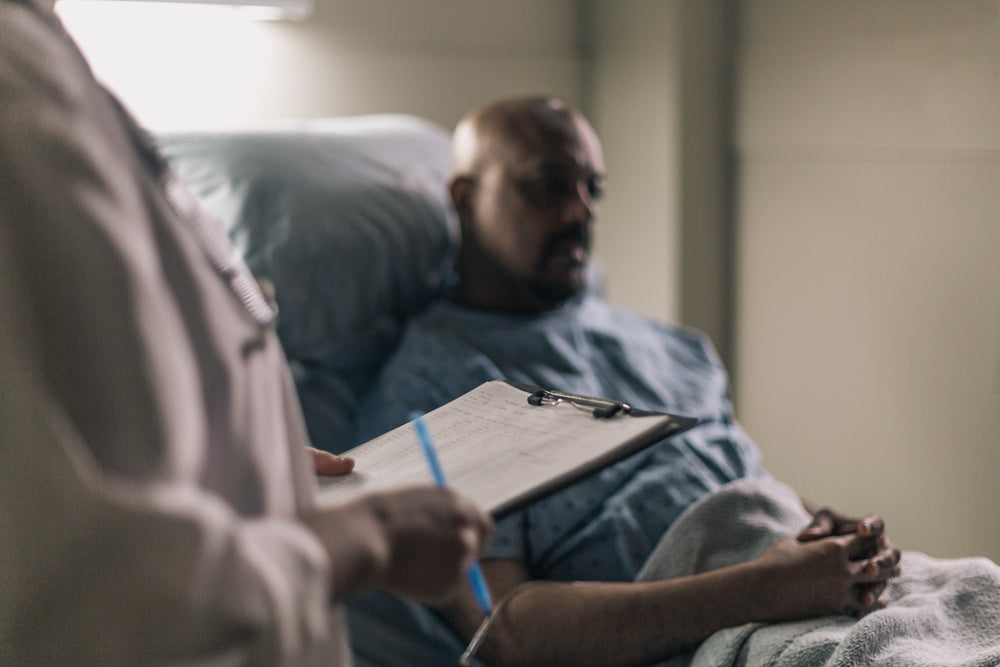 a doctor checks a chart as the patient watches on