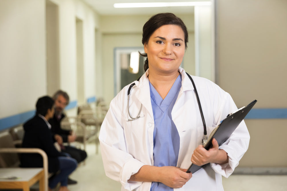 a doctor smiles while holding her clipboard