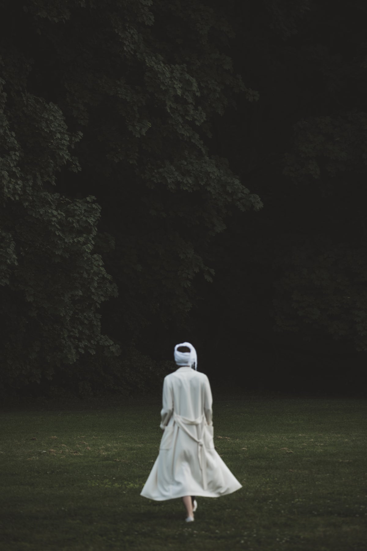 一个穿着白纱布的身影向树林走去