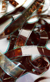 a film reel lays tangled against a white background