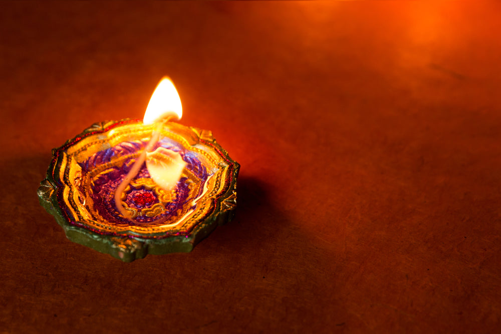 a flower shaped diya lamp glows softly