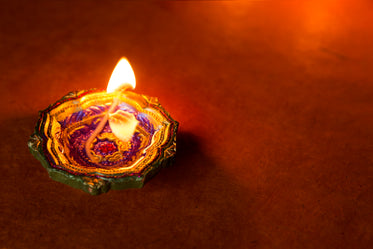 a flower shaped diya lamp glows softly