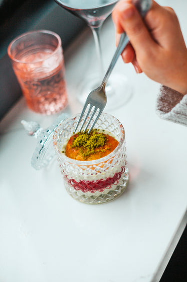 a fork dips into dessert in crystal jar