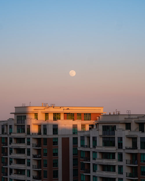 a full moon over buildings