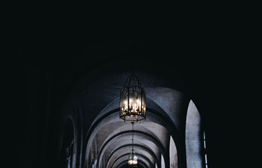 a glass lantern of candles in a corridor of arches