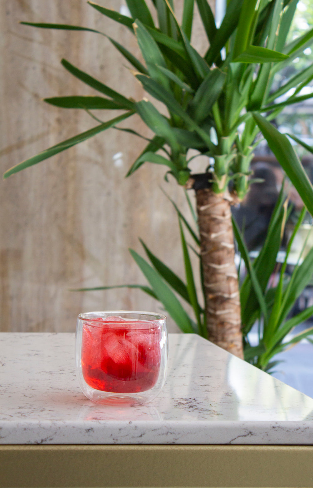 a glass tumbler of juice on a marble counter