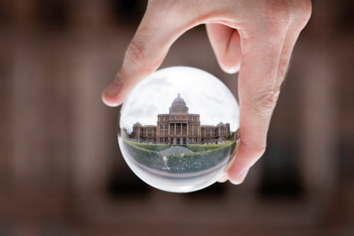 a grand building refracted through a glass orb