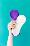a hand brandishes reusable menstrual pads