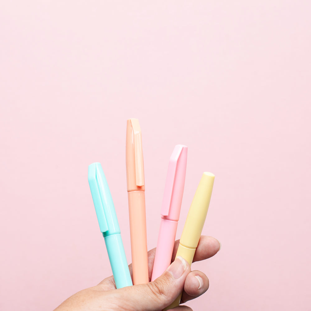 a hand holds four coloured markers