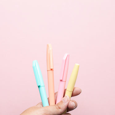 a hand holds four coloured markers