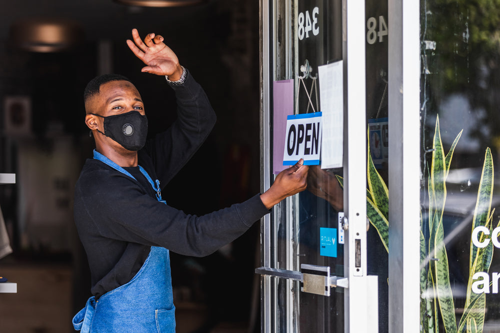 a happy store owner opens for the day