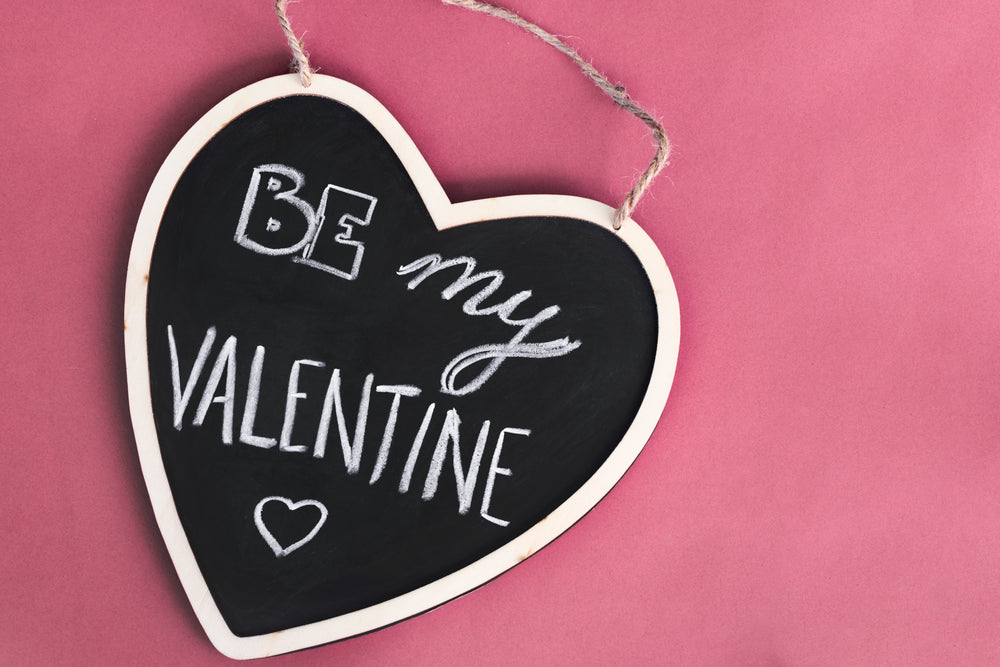 a heart-shaped blackboard on a pink background