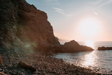 a jagged rocky cliffside meets the ocean water and waves